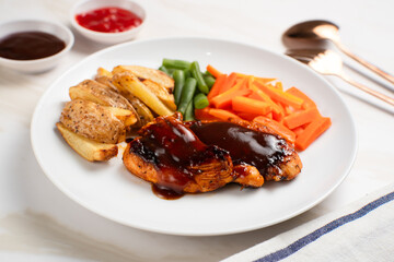 Grilled chicken steak with barbecue sauce, potato wedges, and fresh vegetables. Perfect for healthy lunch, dinner menu content, recipes, articles or any cooking content