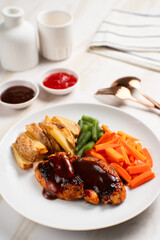 Grilled chicken steak with barbecue sauce, potato wedges, and fresh vegetables. Perfect for healthy lunch, dinner menu content, recipes, articles or any cooking content