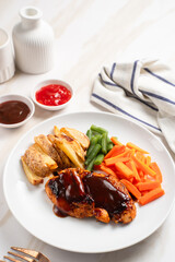 Grilled chicken steak with barbecue sauce, potato wedges, and fresh vegetables. Perfect for healthy lunch, dinner menu content, recipes, articles or any cooking content