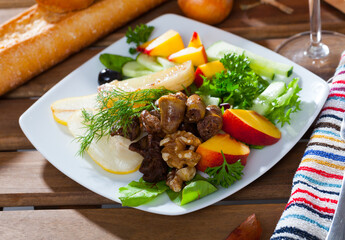 Low-calorie healthy salad with chicken hearts, fresh peachs, pears and fried cheese