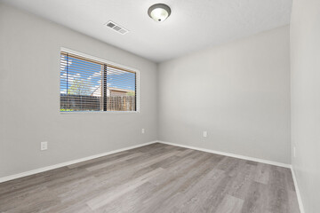 A vacant living room featuring hardwood floors and sliding doors