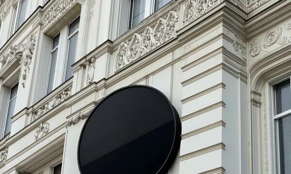  Close-up of a black, round, blank sign on the side wall of an elegant building in Paris. This image can be used as a mockup or template