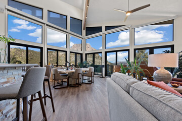 This living room features numerous windows and a stylish ceiling fan
