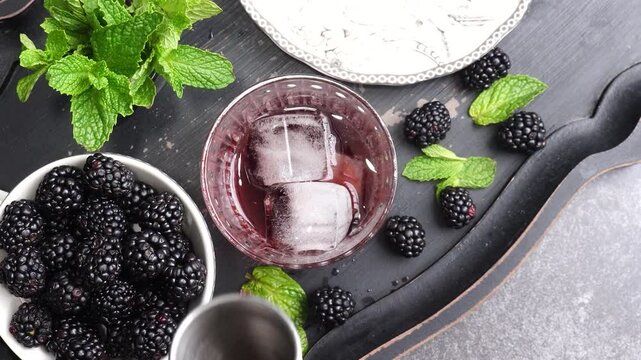 Mixing up a sweet Zipper cocktail with raspberry liqueur, vanilla vodka, sparkling soda, topped with fresh blackberries and mint.  At the bar for happy hour we had a Raspberry type cocktail with ice.