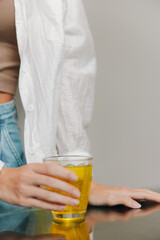 Woman sitting at table with glass of orange juice and cup of coffee in front of her