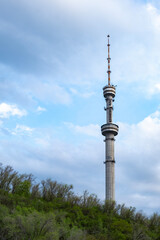 Fototapeta premium Panorama of the TV tower and the city of Almaty in early spring. Flight over the hills with a view of the mountain, the Koktobe tower and the city of Almaty.