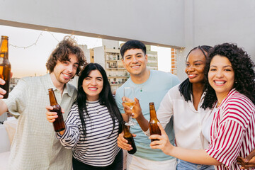 Young Latin friends pose and look at the camera for a photo at a terrace party