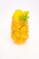 yellow peach and orange citrus drink with fresh mint leaves and ice served in clear glass on white background. High quality photo