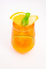 refreshing orange citrus cocktail with sliced lemon and mint leaves served in clear glass over ice on white background. High quality photo
