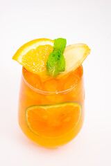 refreshing orange citrus cocktail with sliced lemon and mint leaves served in clear glass over ice on white background. High quality photo