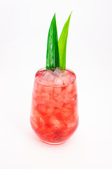 red berry cocktail served in clear glass with crushed ice and green tropical leaves isolated on white background. High quality photo