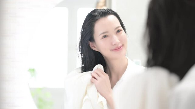 お風呂上りに洗面台の鏡の前で髪の毛をタオルドライする女性の動画
