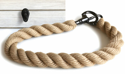 Obraz premium Thick jute rope with black metal clasp, ideal for nautical, rustic, or industrial design projects. Versatile and strong, perfect for DIY crafts and home decor.