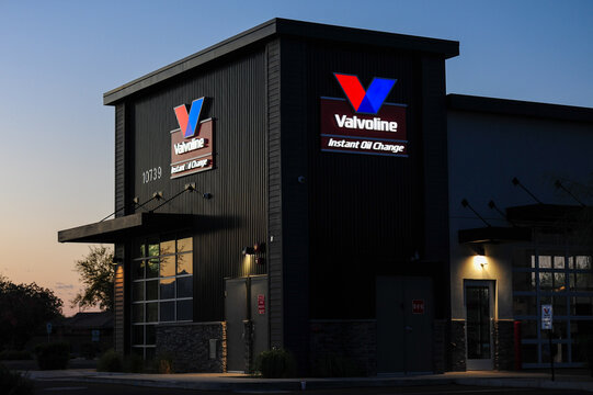 Valvoline Instant Oil Change building at dawn with illuminated signage, showcasing retail automotive maintenance services and branding visibility in after-hours exterior lighting