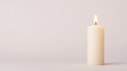 A single white candle burns softly on a plain background, creating a calm and peaceful atmosphere.