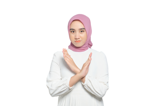 Portrait of young serious Asian Muslim woman showing stop gesture with crossed arms isolated on transparent background