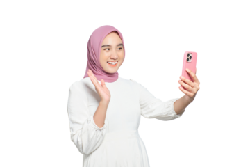 Cheerful young Asian Muslim woman with smartphone making video call or taking selfie isolated on transparent background