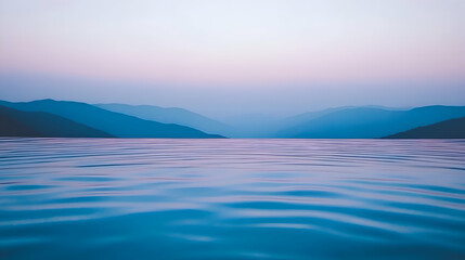 Obraz premium Serene twilight landscape; tranquil blue water reflecting a picturesque mountain range under a soft, pastel sky. Perfect for relaxation or travel themes.