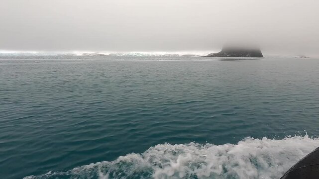Motoring along in Moon Bay in slush and brash ice with Edinburgh Hill South Shetland Island Antarctic Peninsula in the distance 