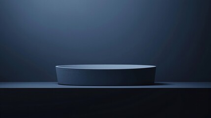 Minimalist dark basin on a smooth surface under soft, moody lighting.