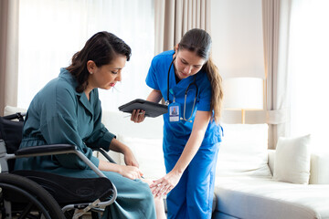 Obraz premium Caregiver checkup and diagnostic leg and knee of woman patient about arthritis while sitting on wheelchair at home, caretaker explaining and examining patient with tablet, insurance and medical.