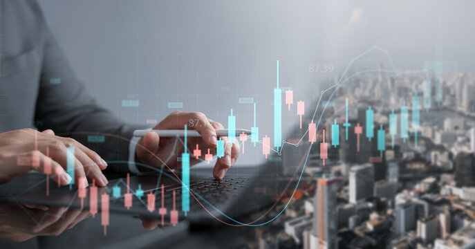 Businessman analyzing stock market charts on laptop with digital candlestick interface and city background, concept of investment, trading, finance, economic data, and financial technology. - Powered by Adobe