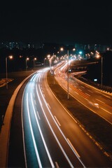 Urban highway at night with light trails from passing vehicles creating a sense of motion and speed