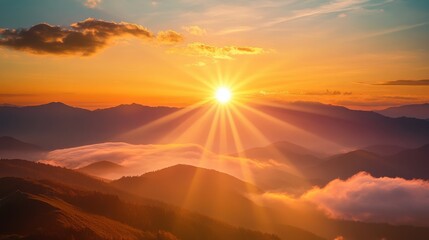 A breathtaking view of the sun dipping below the mountains, surrounded by a glowing golden-orange sky and soft clouds, creating a peaceful evening atmosphere.