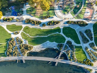 Aerial view of Rotorua, New Zealand, showcasing the city's urban landscape and the scenic Lake Rotorua. People enjoy the park, highlighting the city's blend of nature and urban life.