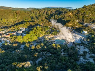 Aerial view of Wai-O-Tapu geothermal area, near Rotorua, New Zealand. Steam rises from the hot springs, a popular tourist destination. The area is known for its colorful pools.