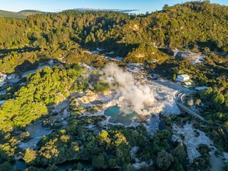 Aerial view of Wai-O-Tapu geothermal area, a popular tourist destination in Rotorua, New Zealand. The image shows steaming pools and unique landscape.