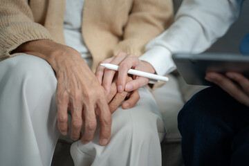 Mental health and elderly care concept.Close up hands of helping hands elderly home care.Arthritis...