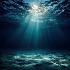 Fototapeta premium Sunlight Streaming Through the Ocean Water Illuminating Sandy Seabed in Deep Blue Sea