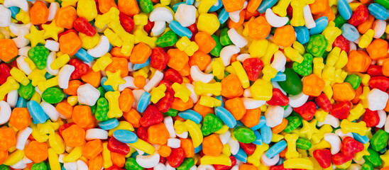 Panoramic background of assorted colorful candies. View from above.