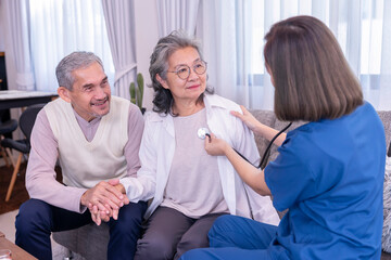 Obraz premium senior couple get physical examination,nurse in uniform using stethoscope listening a woman's chest while husband holding hands to encourage his wife