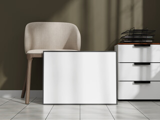 Sleek poster frame mockup positioned on the floor next to a modern beige chair and a stylish desk organizer.