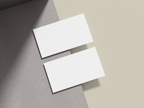 A simple business card mockup placed on a beige cement surface with a sleek shadow, ideal for showcasing minimalist brand logos.