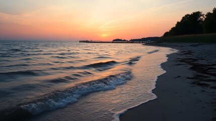 Sunset Over Calm Waters With Gentle Waves Lapping on Sandy Shore Near Pier Surrounded by Trees in Tranquil Evening Atmosphere