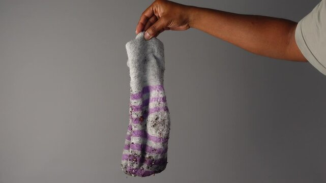 hand holding a dirty sock 