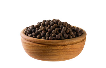 allspice or Jamaican pepper seeds in a wooden bowl isolated on white background.