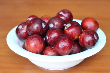 Ripe plum, fresh red plum fruits in a bowl