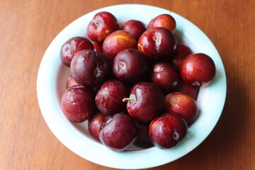 Ripe plum, fresh red plum fruits in a bowl