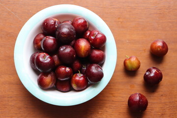 Ripe plum, fresh red plum fruits in a bowl