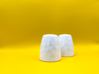 Salt and pepper container on the yellow color background.
