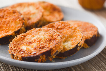 Fried breaded eggplant aubergine slices, vegetarian cutlet, milanese or schnitzel served on blue...