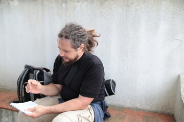 Journalist writing notes outdoors, taking a break from reporting