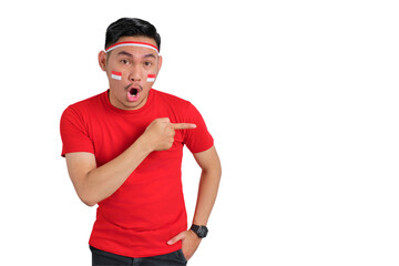 Shocked young Asian man celebrating Indonesian independence day pointing aside at copy space isolated on transparent background