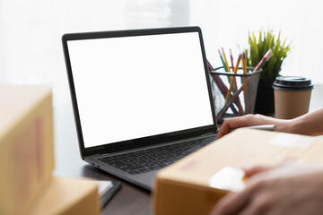Hand using a computer laptop with a blank screen on table, for putting advertising to promote