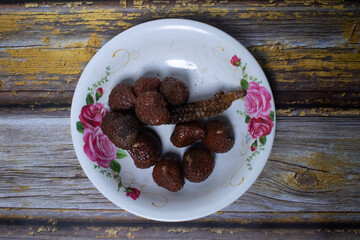 A simple serving of kelubi fruit on a plate decorated with flowers.
