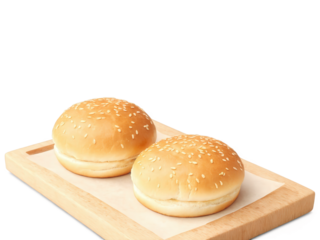 Two soft, lightly toasted burger buns on a cutting board. The buns have a golden-brown crisp exterior with a fluffy,